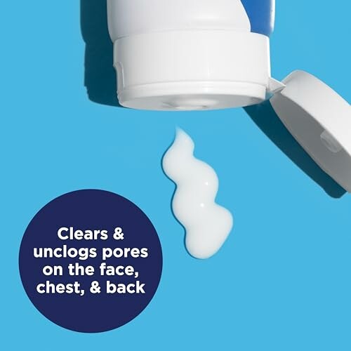 Open skincare tube with lotion on blue surface.